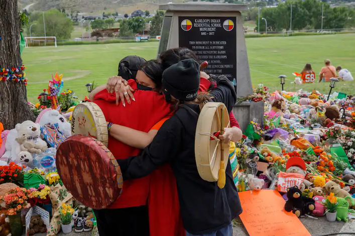 People from the Mosakahiken Cree Nation hug in front of a memorial at the former Kamloops Indian Residential School -Cole Burston:AFP:Getty